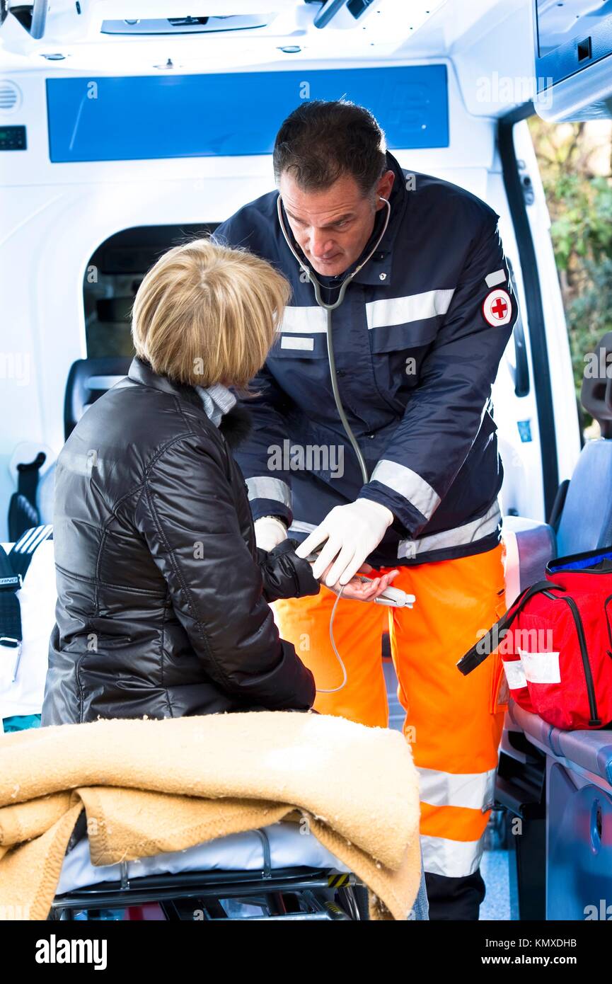 Male Paramedic Assistting Injured Woman Stock Photo