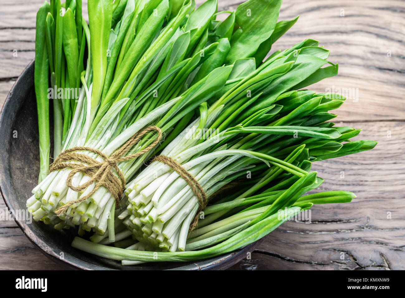 Young fresh wild garlic on the wooden table Stock Photo - Alamy
