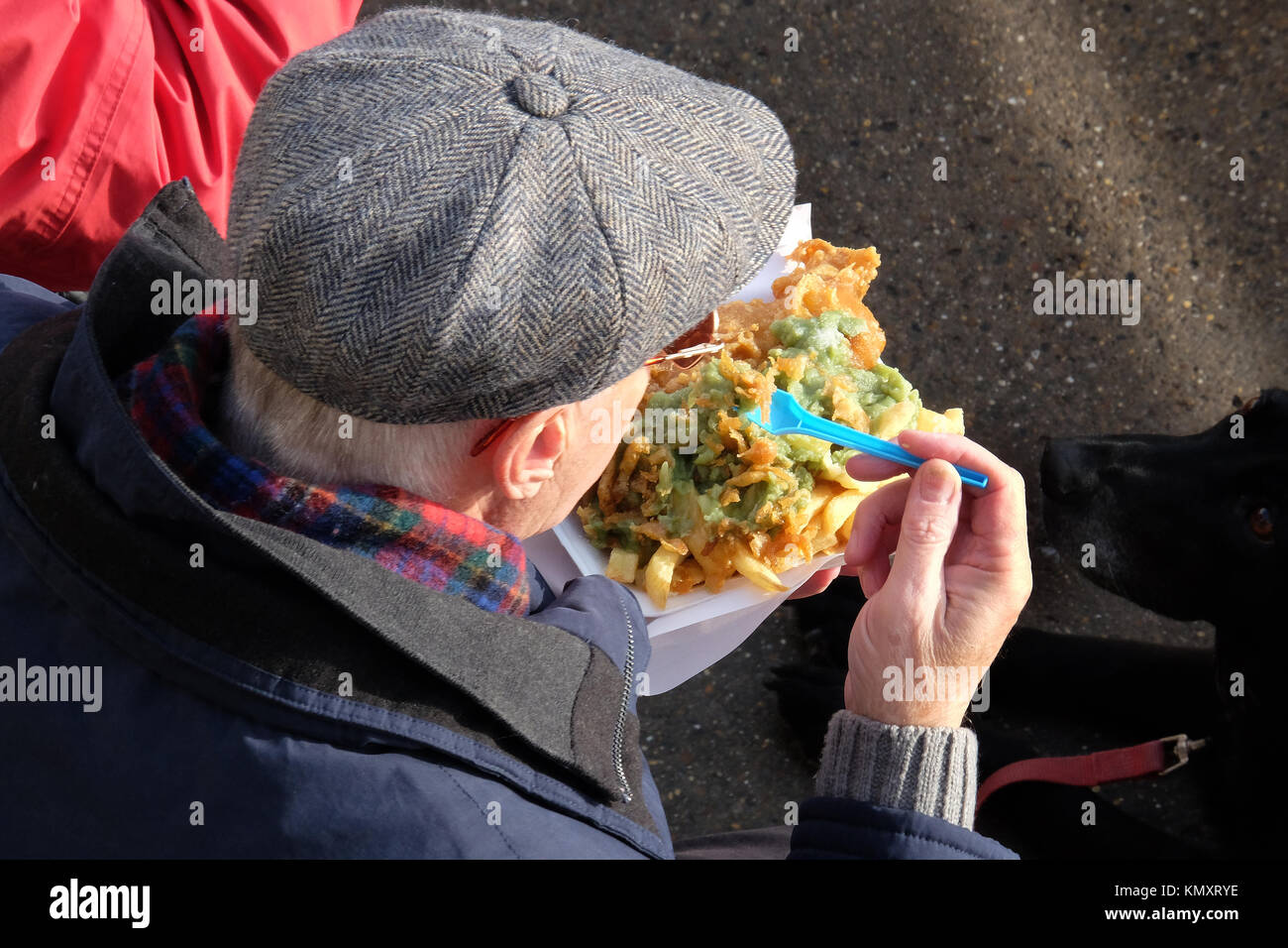 Man eating fast food outdoors. Fish, chips and peas. Stock Photo