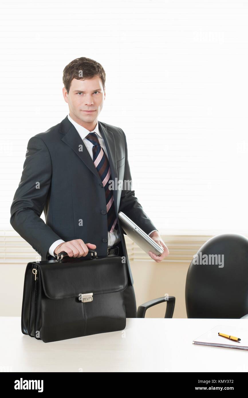 Businessman in his office with briefcase Stock Photo Alamy
