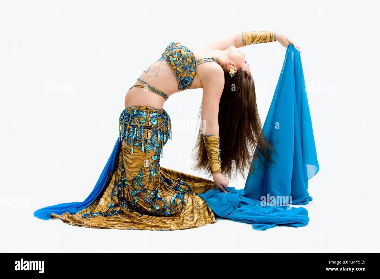 Beautiful belly dancer in blue outfit holding veil bending backward, isolated Stock Photo