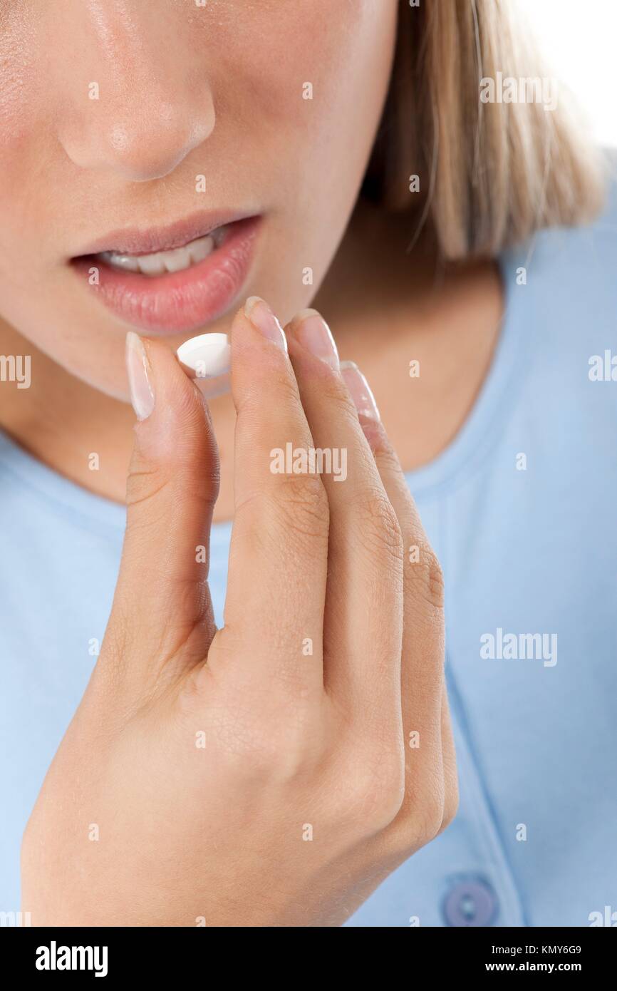 Young woman taking pills Stock Photo