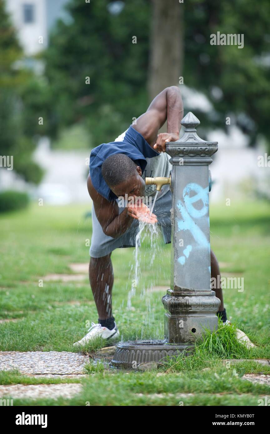 Young man drinking from a fountain Stock Photo Alamy