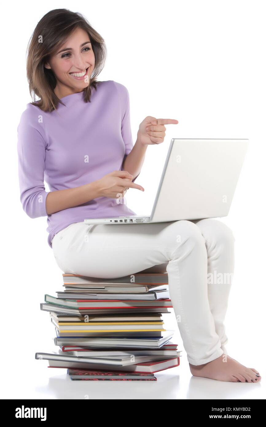 Smiling woman sitting on stack of books Stock Photo - Alamy