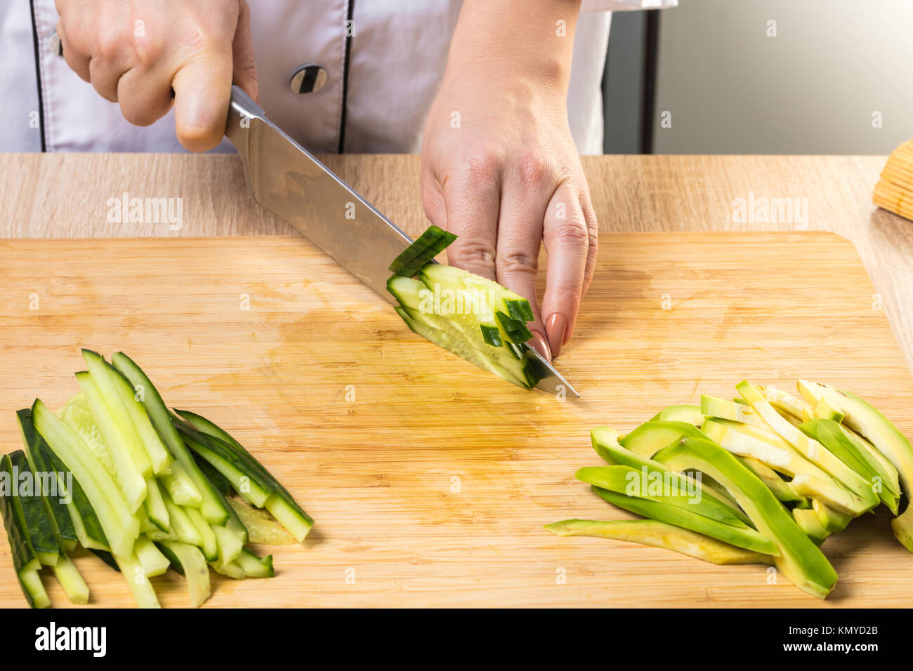 The process of making Japanese sushi. Knife in hand cuts a roll close-up on  a wooden board Stock Photo - Alamy