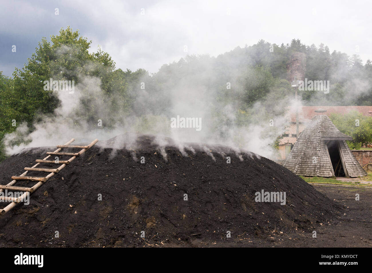 Charcoal burning in a charcoal pile at the Château de Fleckenstein, Lembach, Alsace Stock Photo