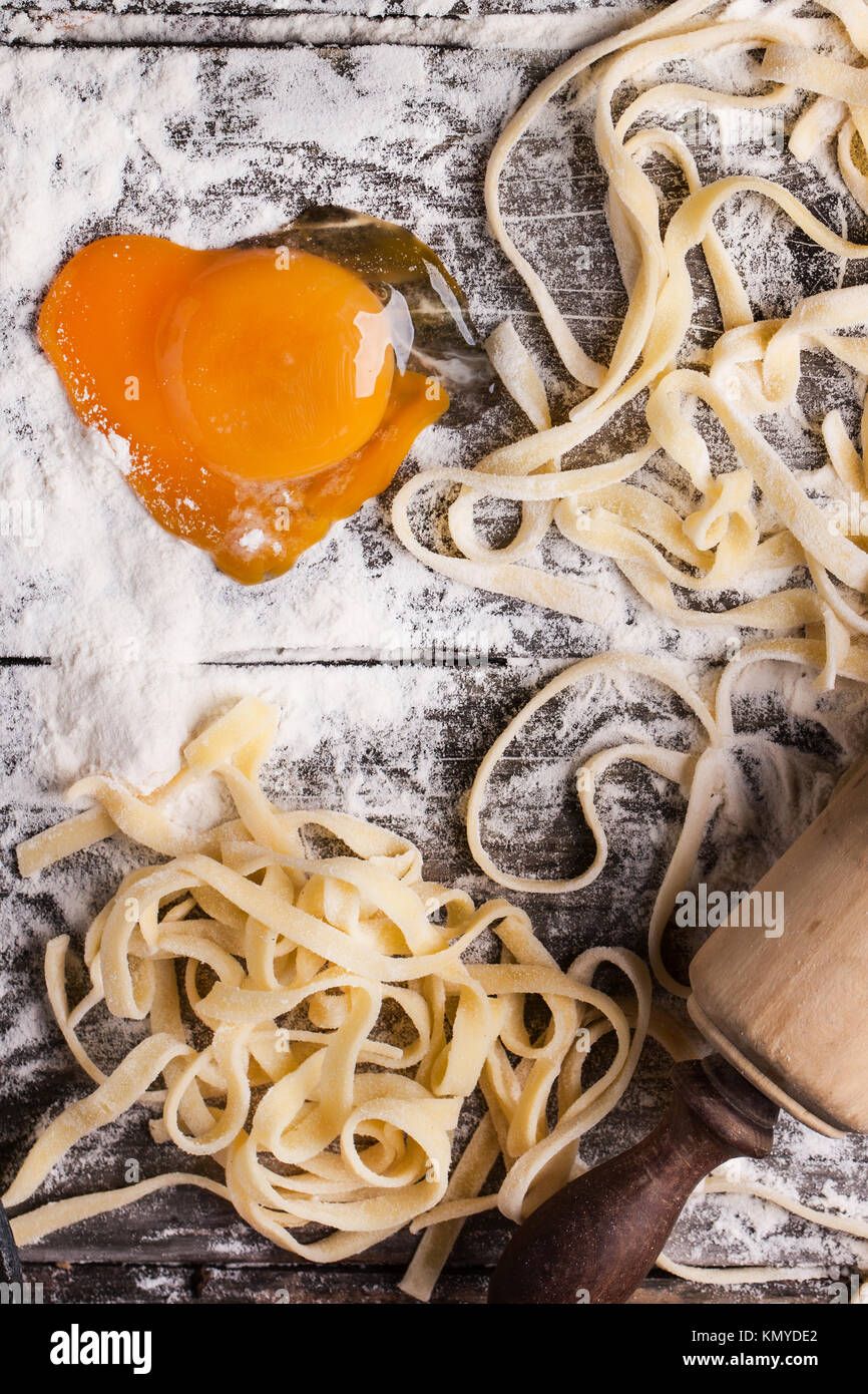 Top view on raw homemade pasta with flour, sea salt and raw egg yolk as