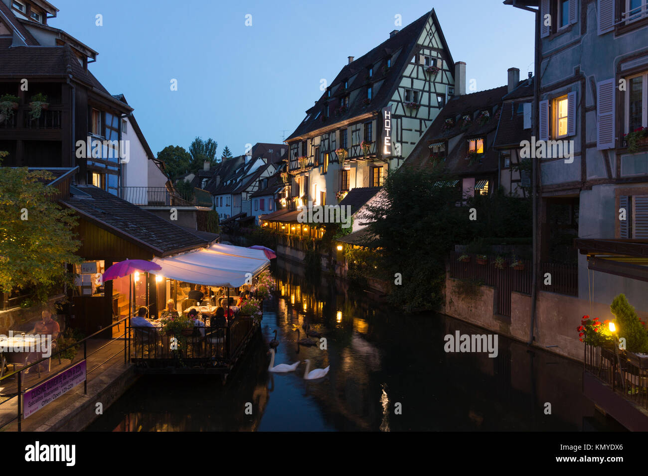 Diners eating out at Les Bateliers restaurant next to La Lauch river and Maisons à Colombage in the Petite Venise quarter of Colmar, Alsace, France Stock Photo