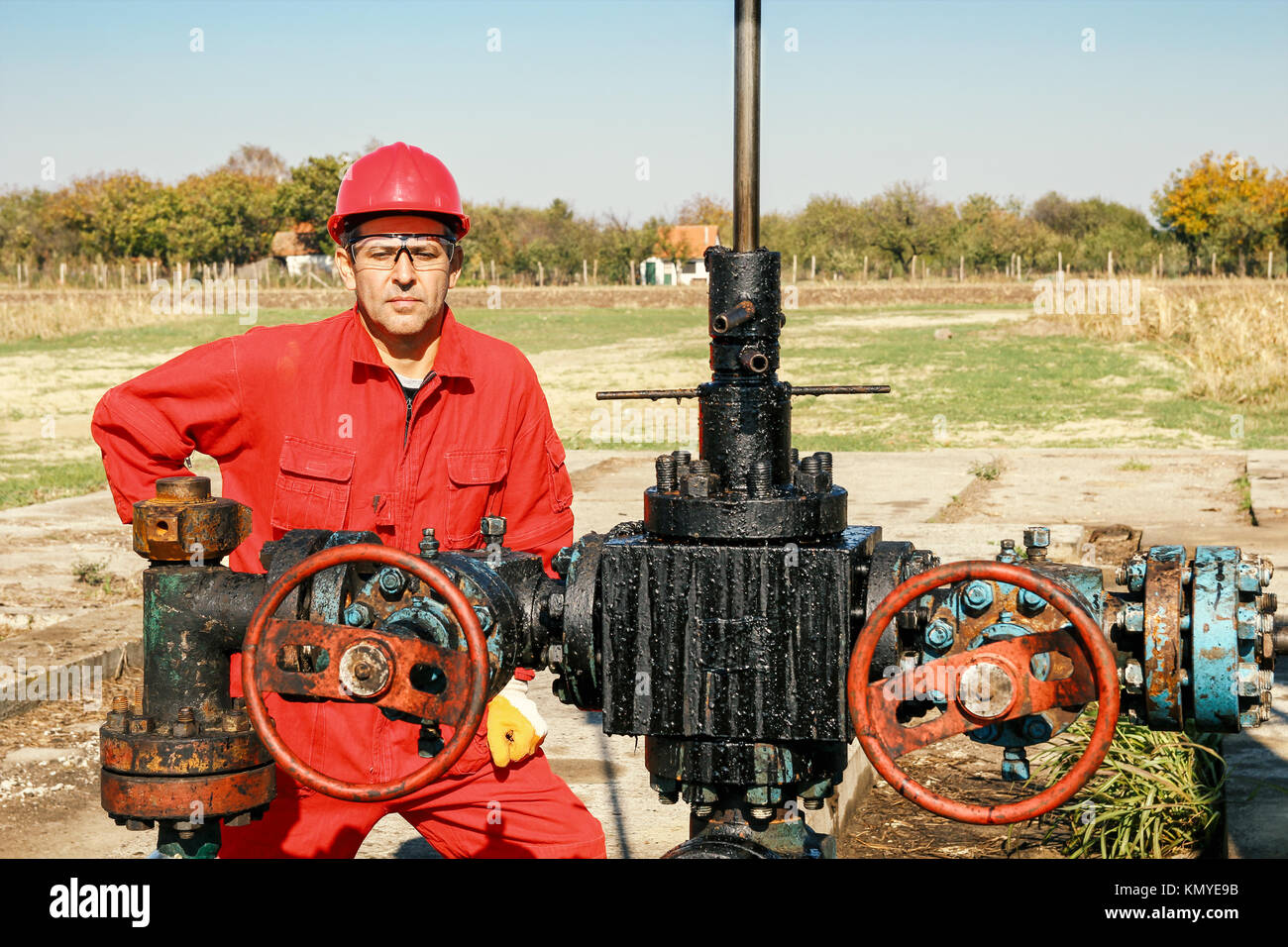 Portrait of a worker beside pump jack oil well. Stock Photo