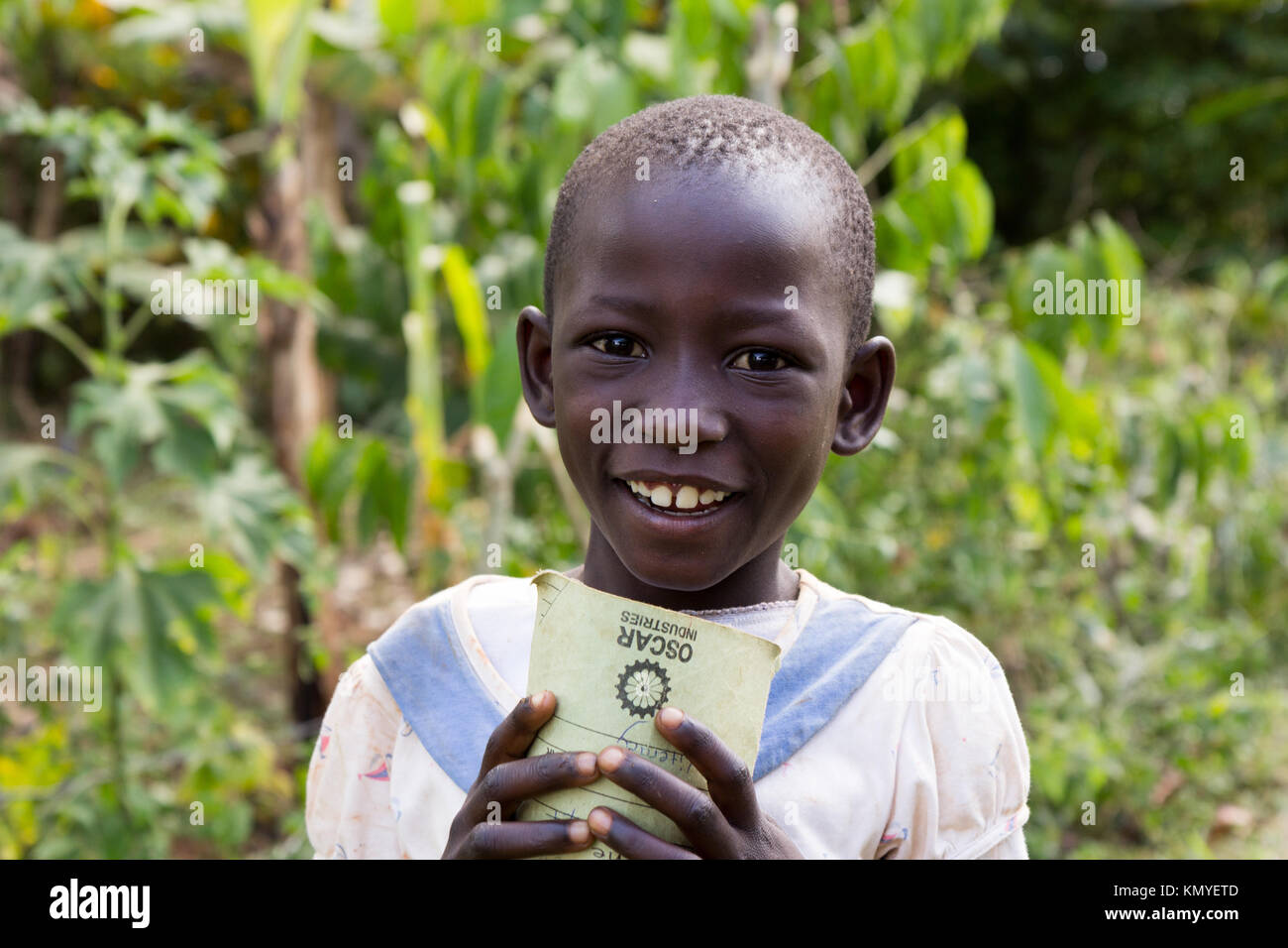 A smiling Ugandan girl holding a notebook. Stock Photo