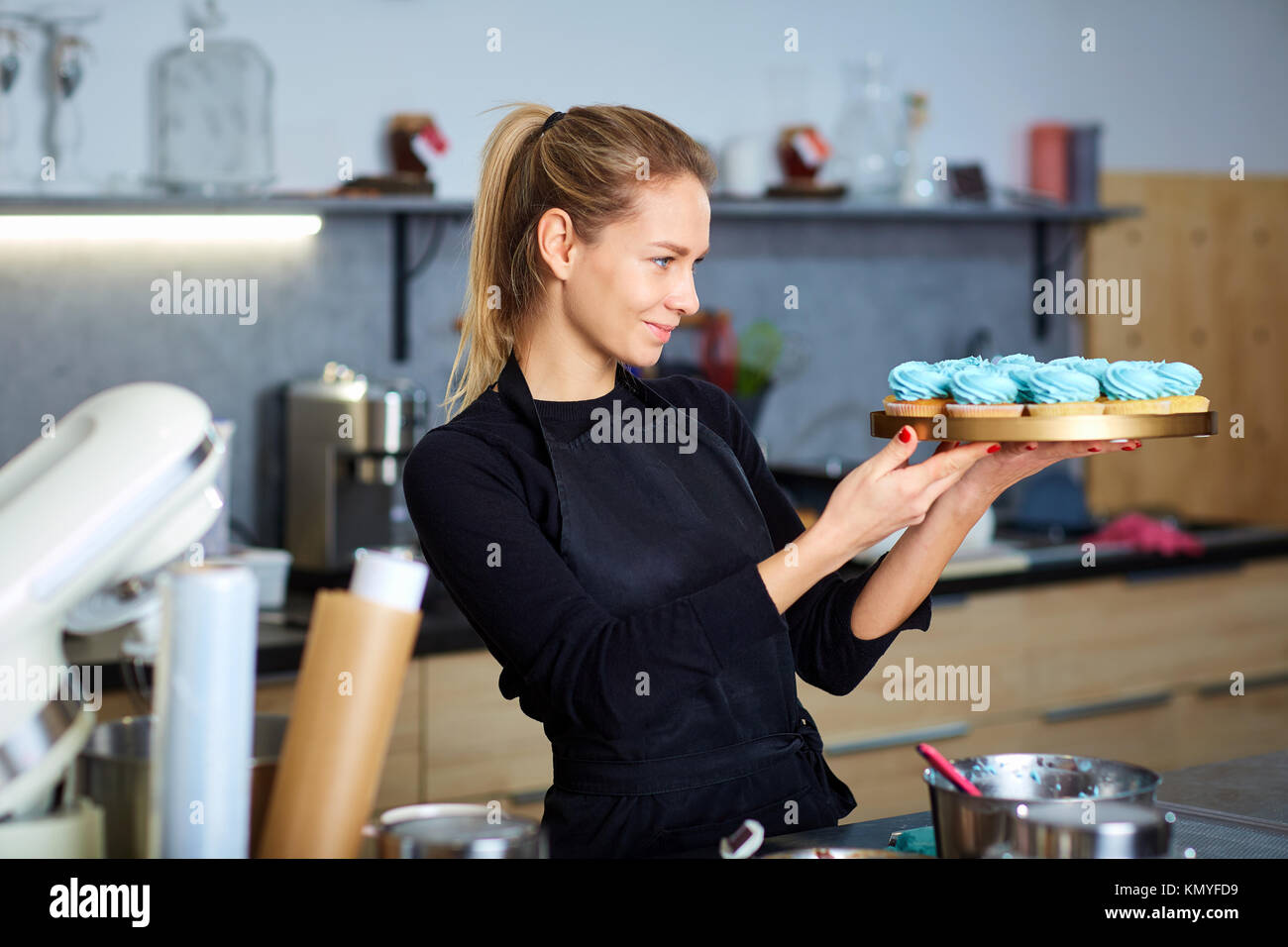 https://c8.alamy.com/comp/KMYFD9/confectioner-pastry-woman-holding-a-tray-of-cupcakes-KMYFD9.jpg