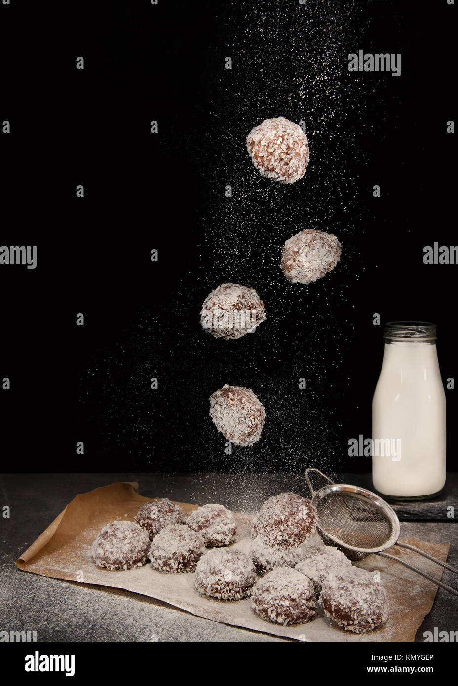 Levitating chocolate and coconut coated marshmallows against black background Stock Photo