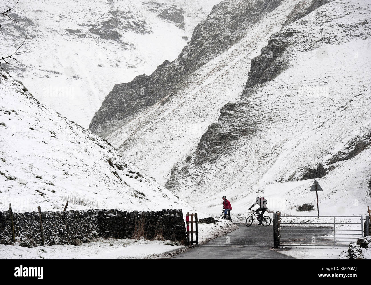 Cyclists at Winnats Pass in the Peak District, as widespread disruption is expected as snow continues to fall across large parts of the UK, with forecasters warning some communities could be cut off as temperatures plummet. Stock Photo