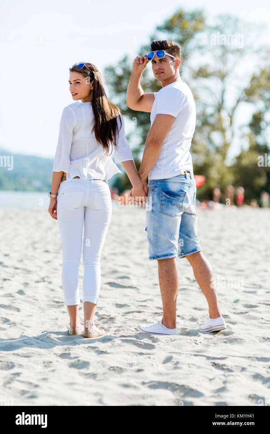 Young couple holding hands on a beach Stock Photo - Alamy