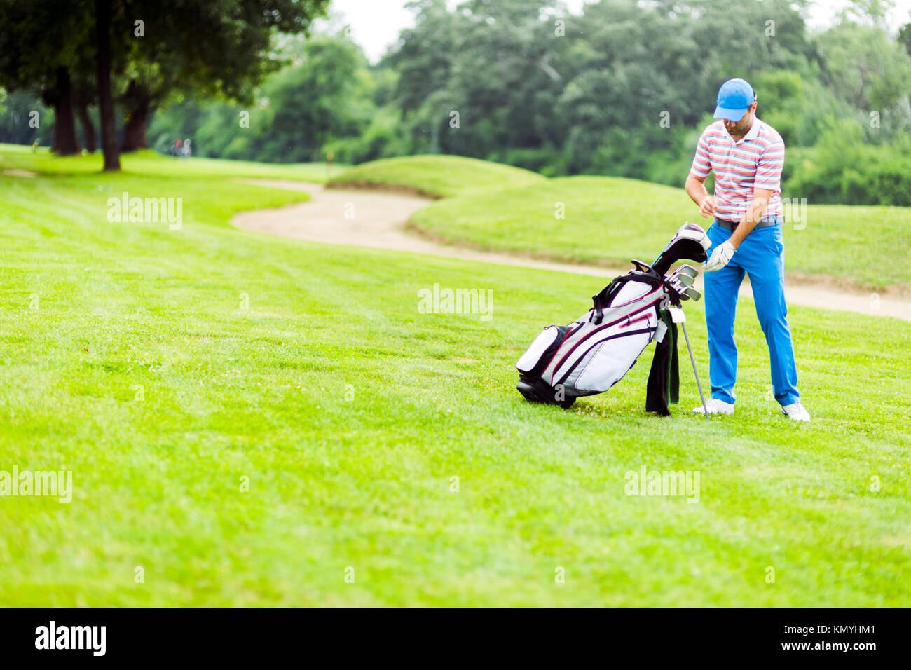 Golfer selecting appropriate club Stock Photo