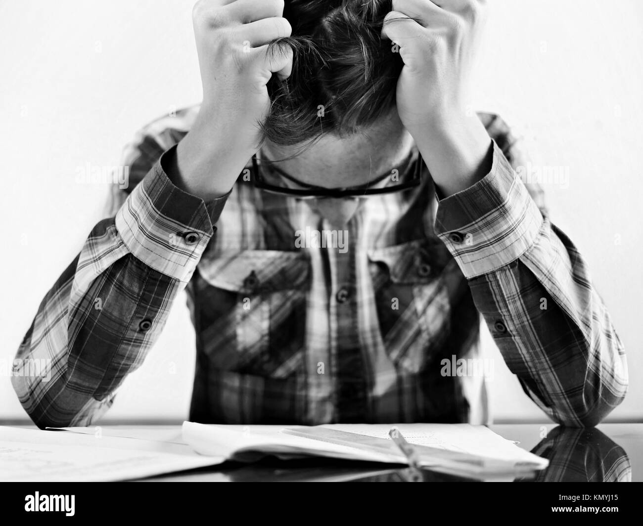 The student with glasses teenager does a homework, he is just studying. Study concept. Stock Photo