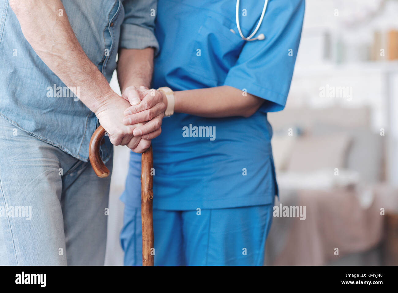 Close up of female nurse helping elderly patient to walk Stock Photo