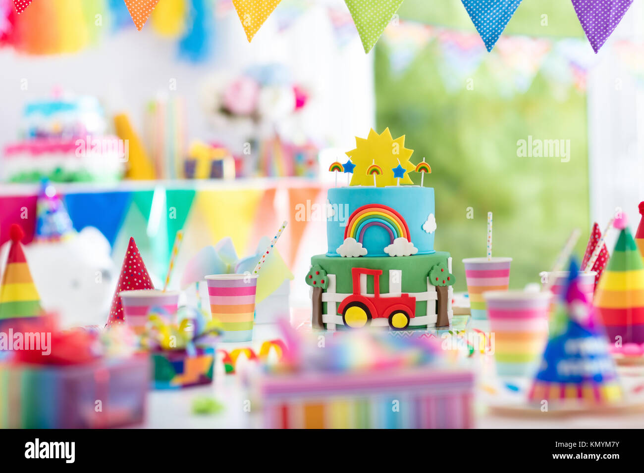 Kids birthday party decoration. Colorful cake with candles. Farm and transportation theme boys party. Decorated table for child birthday celebration.  Stock Photo