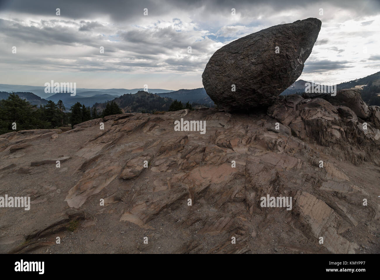 Large boulder balances on the cliff edge in volcano ravaged Lassen Volcanic National Park Stock Photo