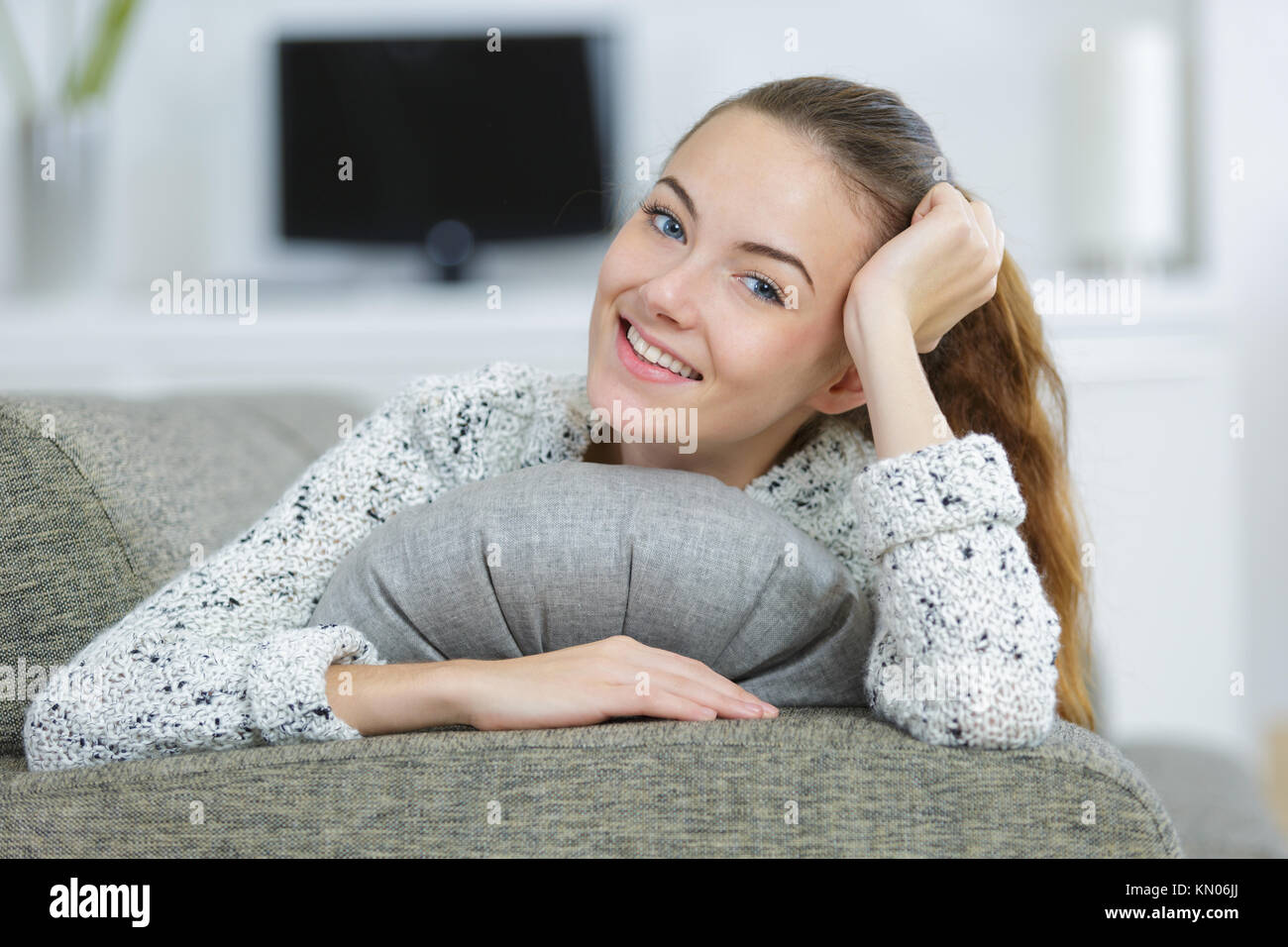 pretty young woman at home lying on the sofa Stock Photo - Alamy