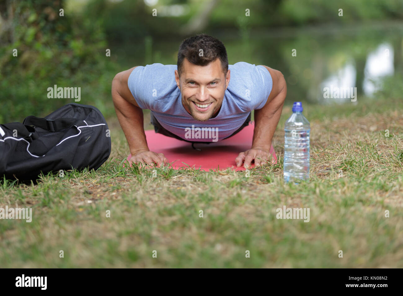 happy man doing push upson grass in summer Stock Photo - Alamy