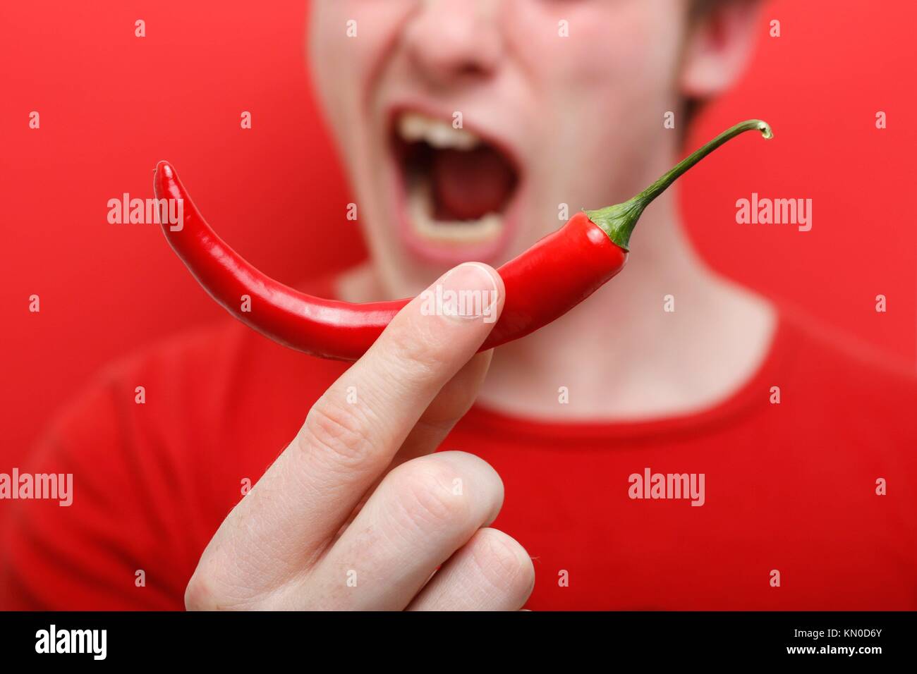 A man eating chili pepper Stock Photo - Alamy
