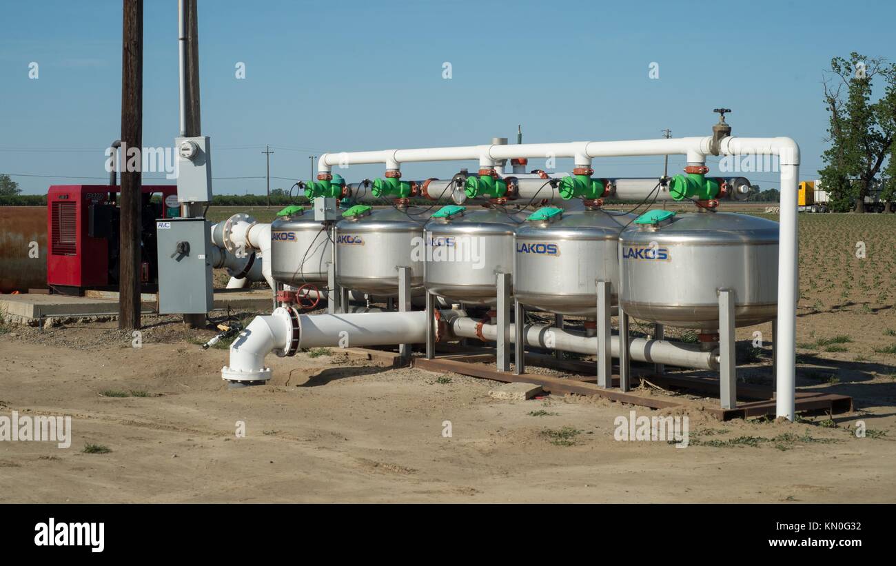 A sand media filtration tank system waters rows of tomatoes at the