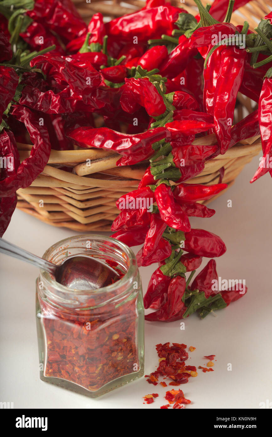 Spicy red pepper ground in the glass jar, with healthy dried peppers in the basket Stock Photo