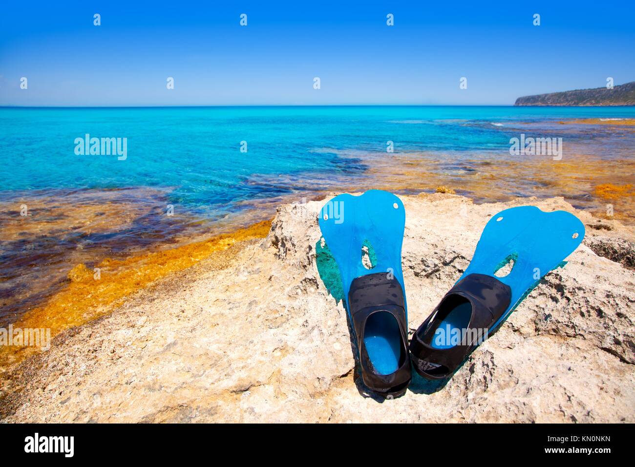 Balearic Formentera island with scuba diving blue fins on a rock Stock