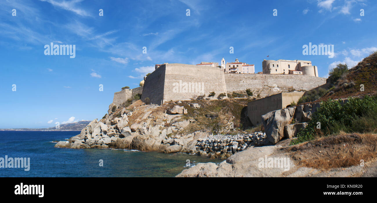 Corsica: Mediterranean Sea and view of the skyline of the Citadel of Calvi, famous tourist destination on the northwest coast, with its ancient walls Stock Photo