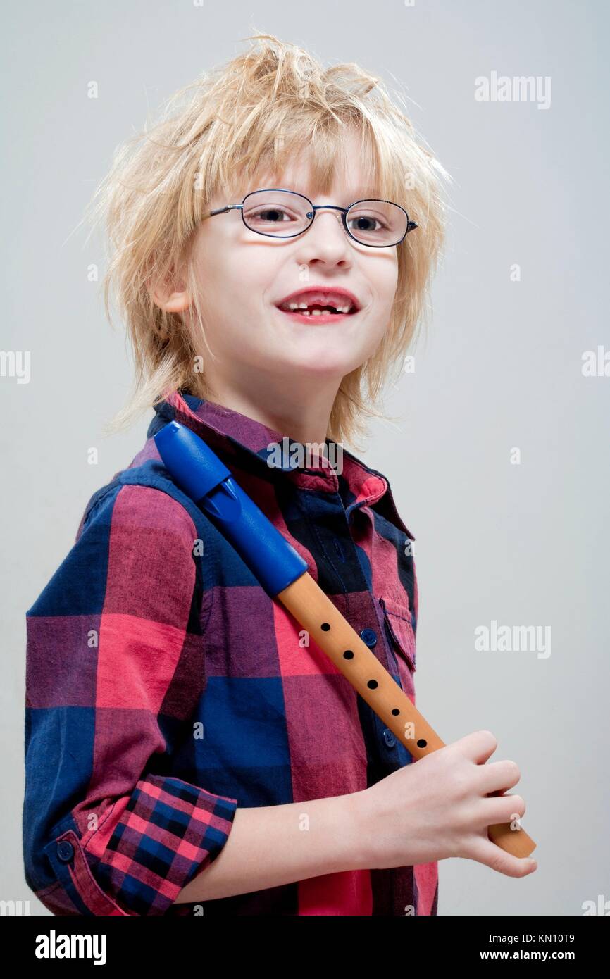 boy with missing milk teeth and glasses holding his flute - isolated on  gray Stock Photo - Alamy