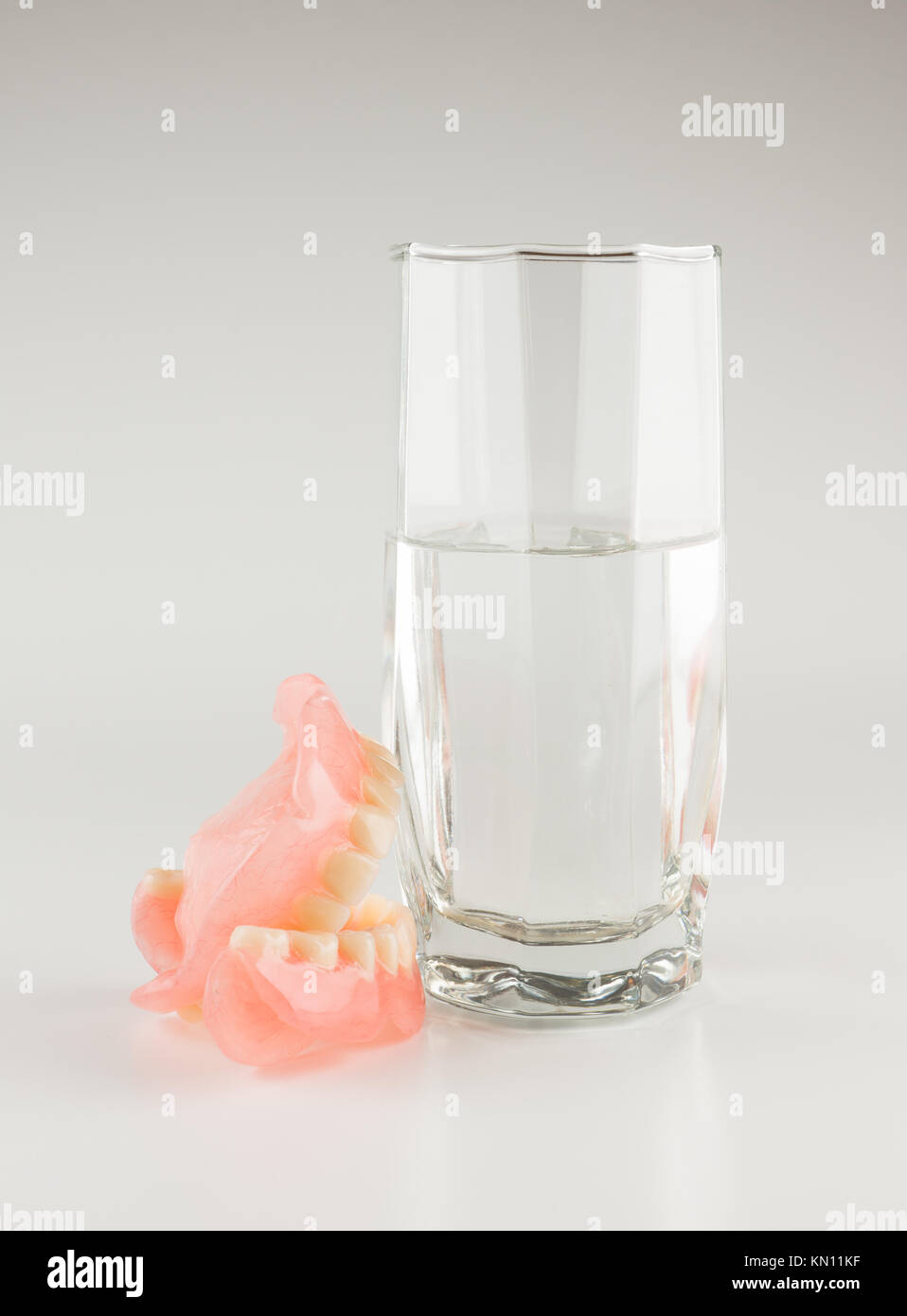 Acrylic removable prosthesis lies on a white background Stock Photo