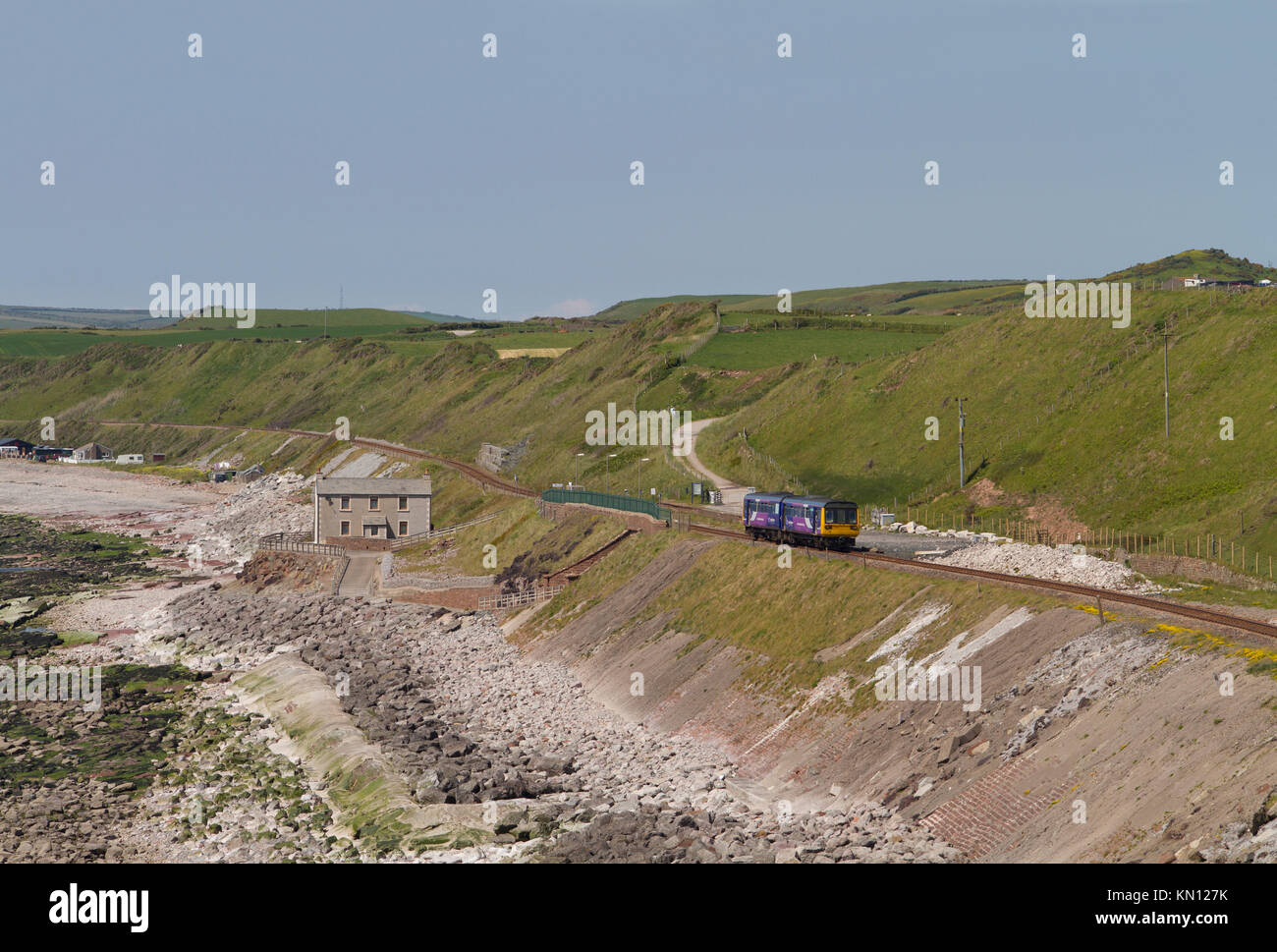 A Northern Rail class 142 Pacer train passing along the Cumbrian Coast railway line near Nethertown. Stock Photo