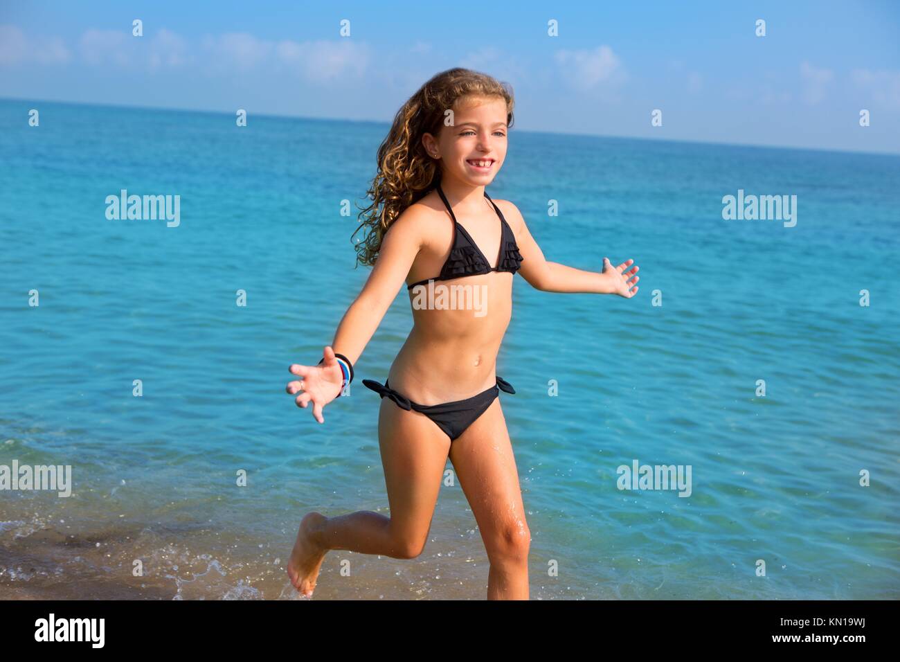 blue beach kid girl with bikini jumping and running splashing water Stock  Photo - Alamy