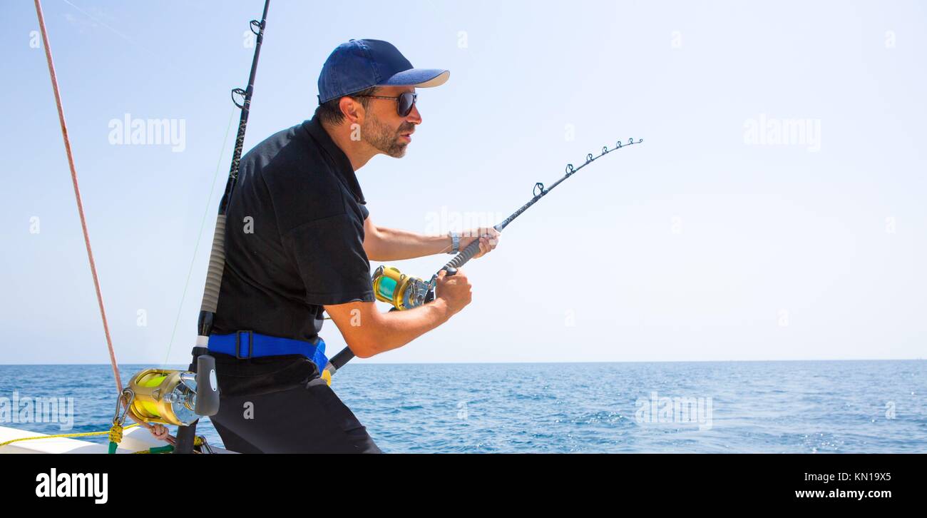 blue sea offshore fishing boat with fisherman holding rod in action