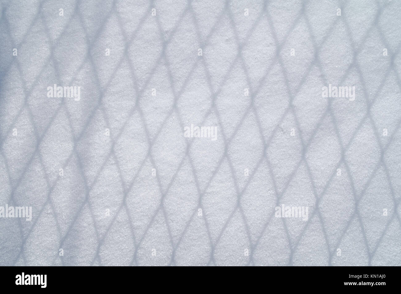 shadow of wire mesh on the snow Stock Photo