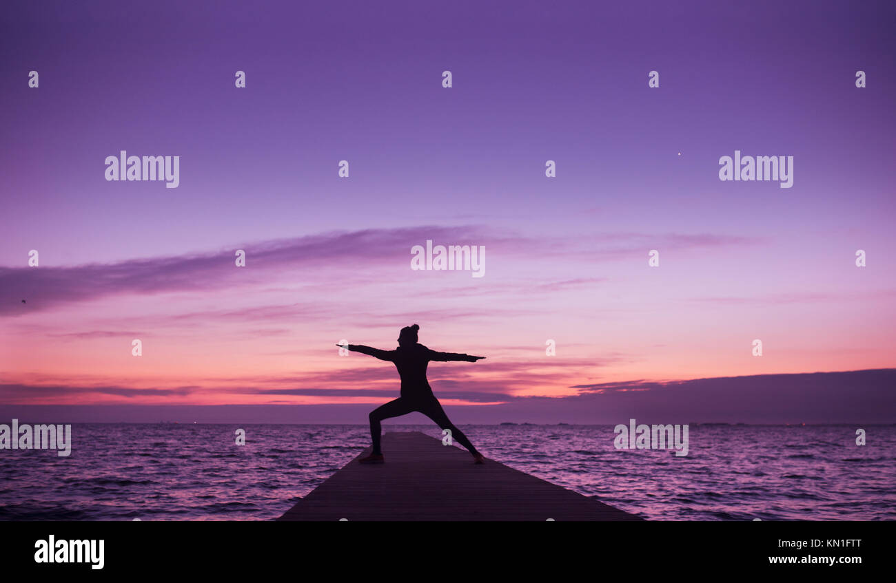 young woman doing yoga on the beach in sunrise Stock Photo Alamy