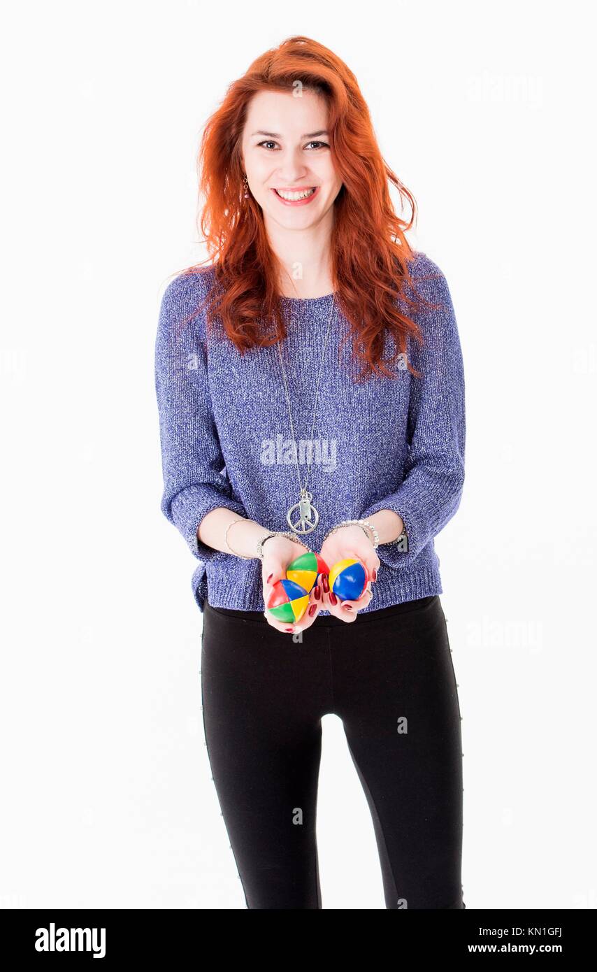 Portrait of attractive young woman holding juggling balls. Stock Photo