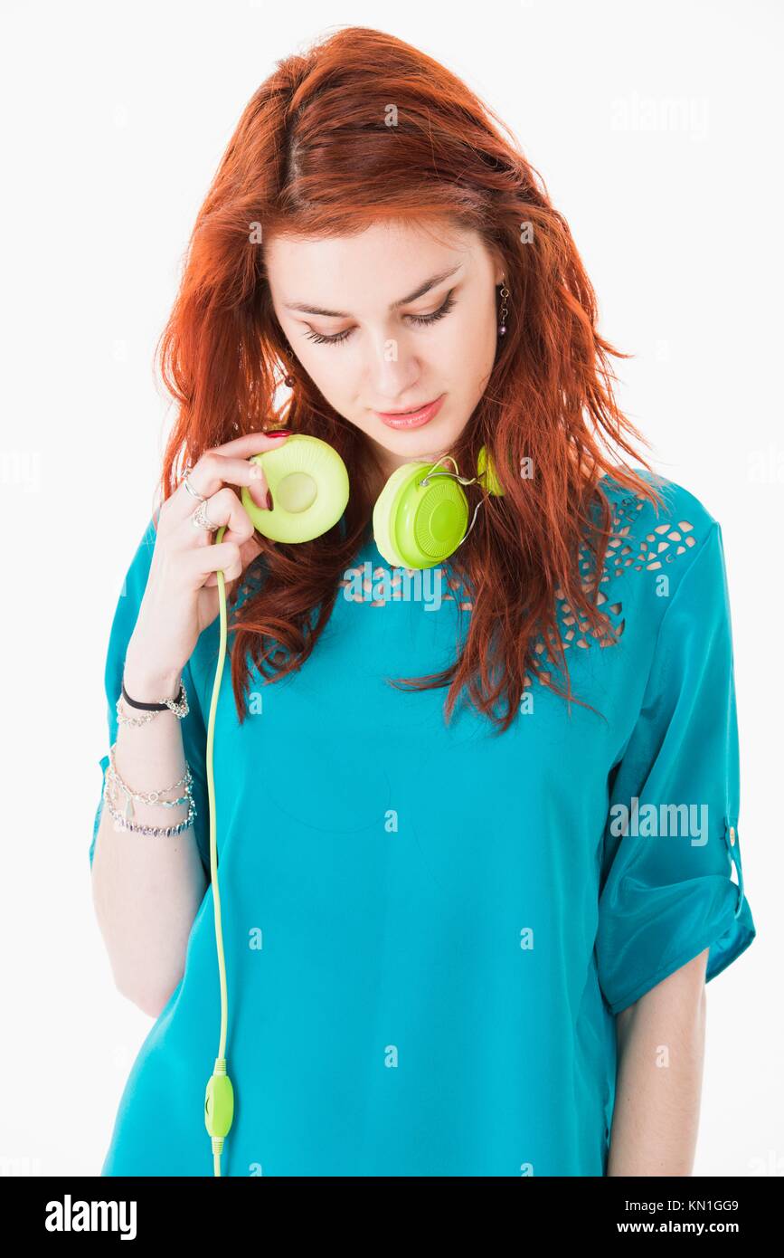Lifestyle portrait of smiling pretty young woman with green headphones. Stock Photo