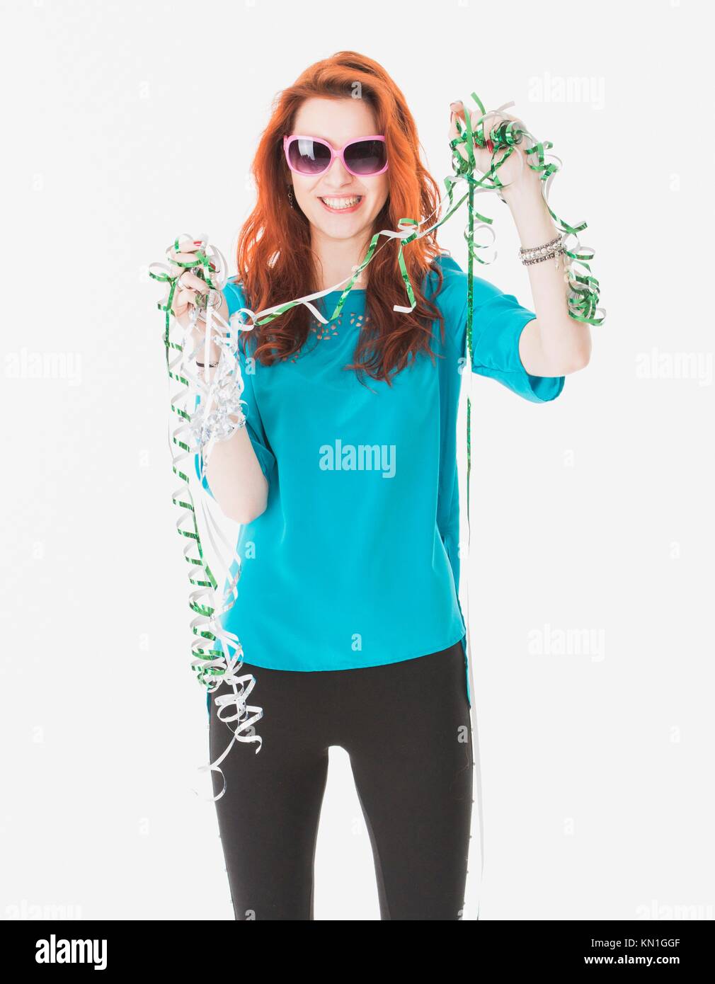 Attractive and happy young woman celebrating with party streamers. Stock Photo