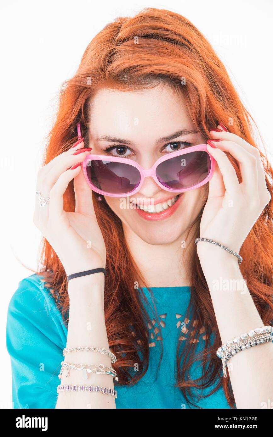 Confident and cool young woman with red hair wearing sunglasses. Stock Photo
