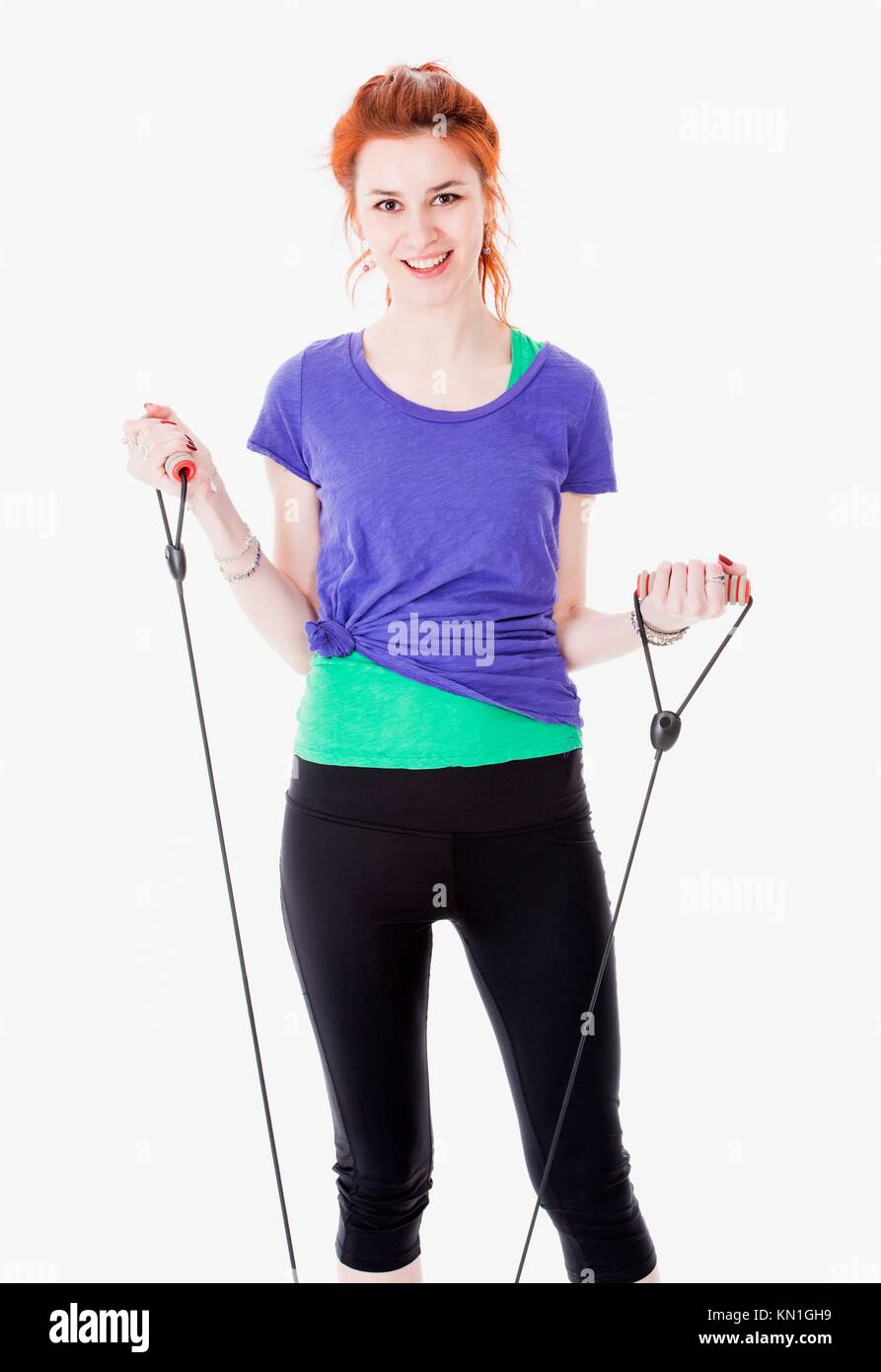 Studio portrait of attractive young woman training with rubber band. Stock Photo