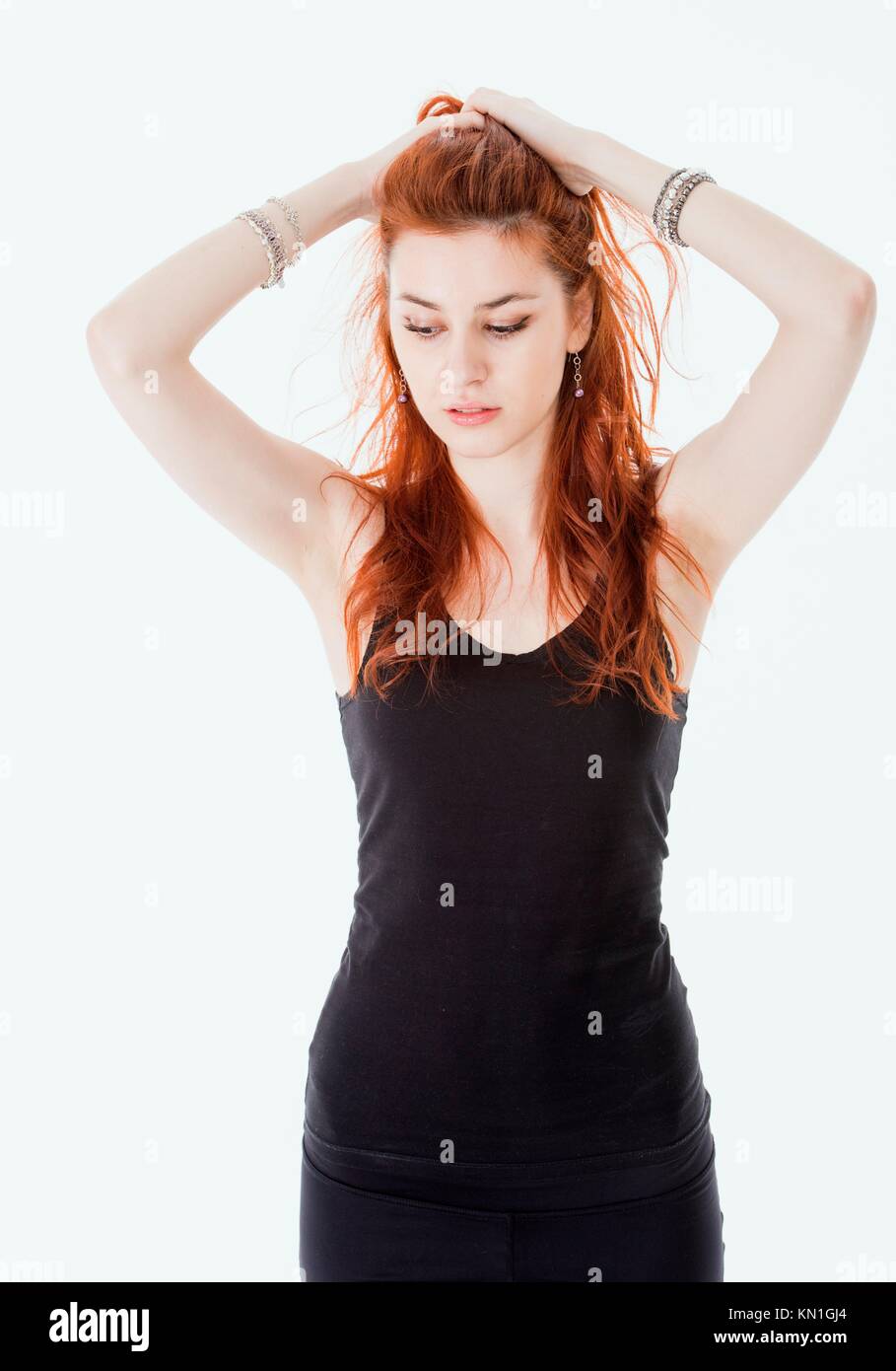 Portrait of attractive young woman with red hair and black dress. Stock Photo