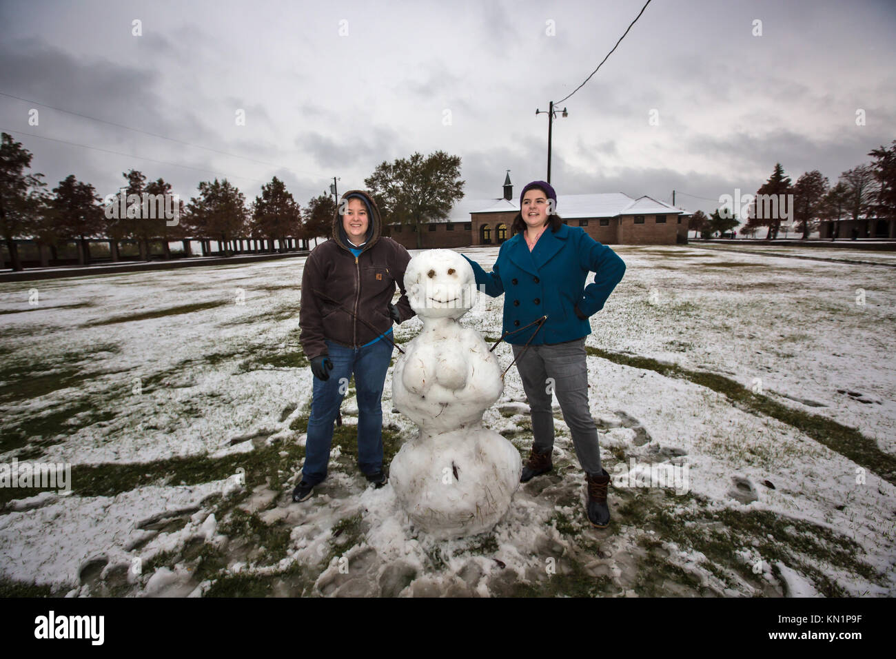 Mandeville, Louisiana, USA. 8th Dec, 2017. SNOW FALLS IN SOUTHERN LOUISIANA on the shore of Lake Pontchartrain in Fontainebleau State Park on Dec. 8, 2017. Molly Ganger and Rose Highnote pose with a snowman they built in the late afternoon. A wintry mix of precipitation fell across several Deep South states causing many businesses and schools to shut down. Credit: Julie Dermansky/ZUMA Wire/Alamy Live News Stock Photo