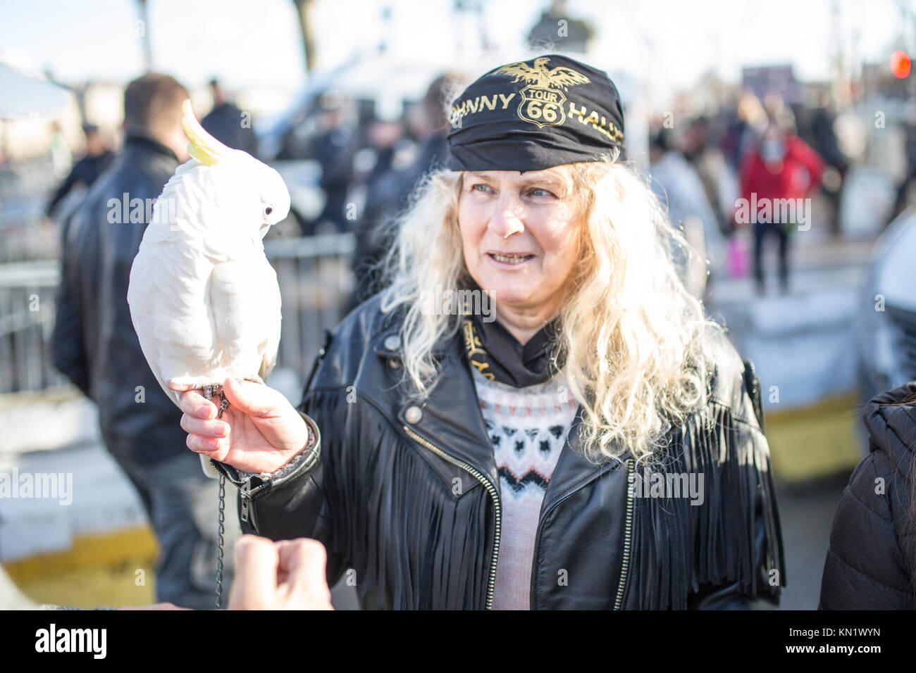Popular commemoration of the death of French singer Johnny Hallyday in Paris: a blond air biker girl with a whithe parrot Stock Photo