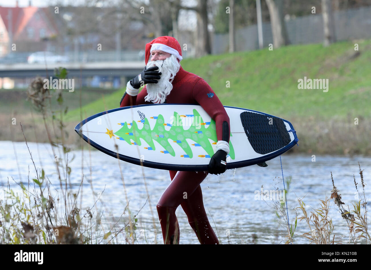 Rastatt, Germany. 09th Dec, 2017. The cold temperatures could not restrain Surfer Thomas Schmidt (50) from Rastatt in Germany going in the Murg-River in Rastatt to engage his passion Surfing. Dressed in a red neoprene Santa Claus suit Credit: dpa picture alliance/Alamy Live News Stock Photo