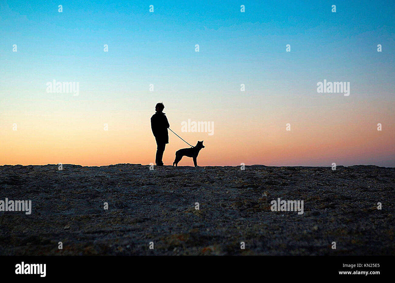 Man and dog at sunset Stock Photo
