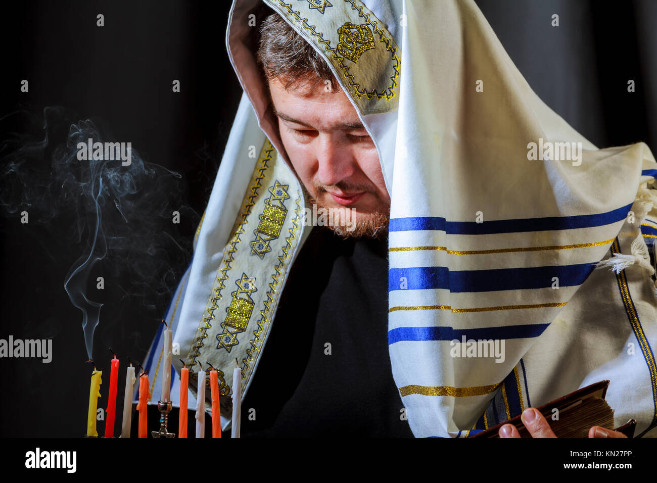 Jewish candle lights male hand lighting candles in menorah on table