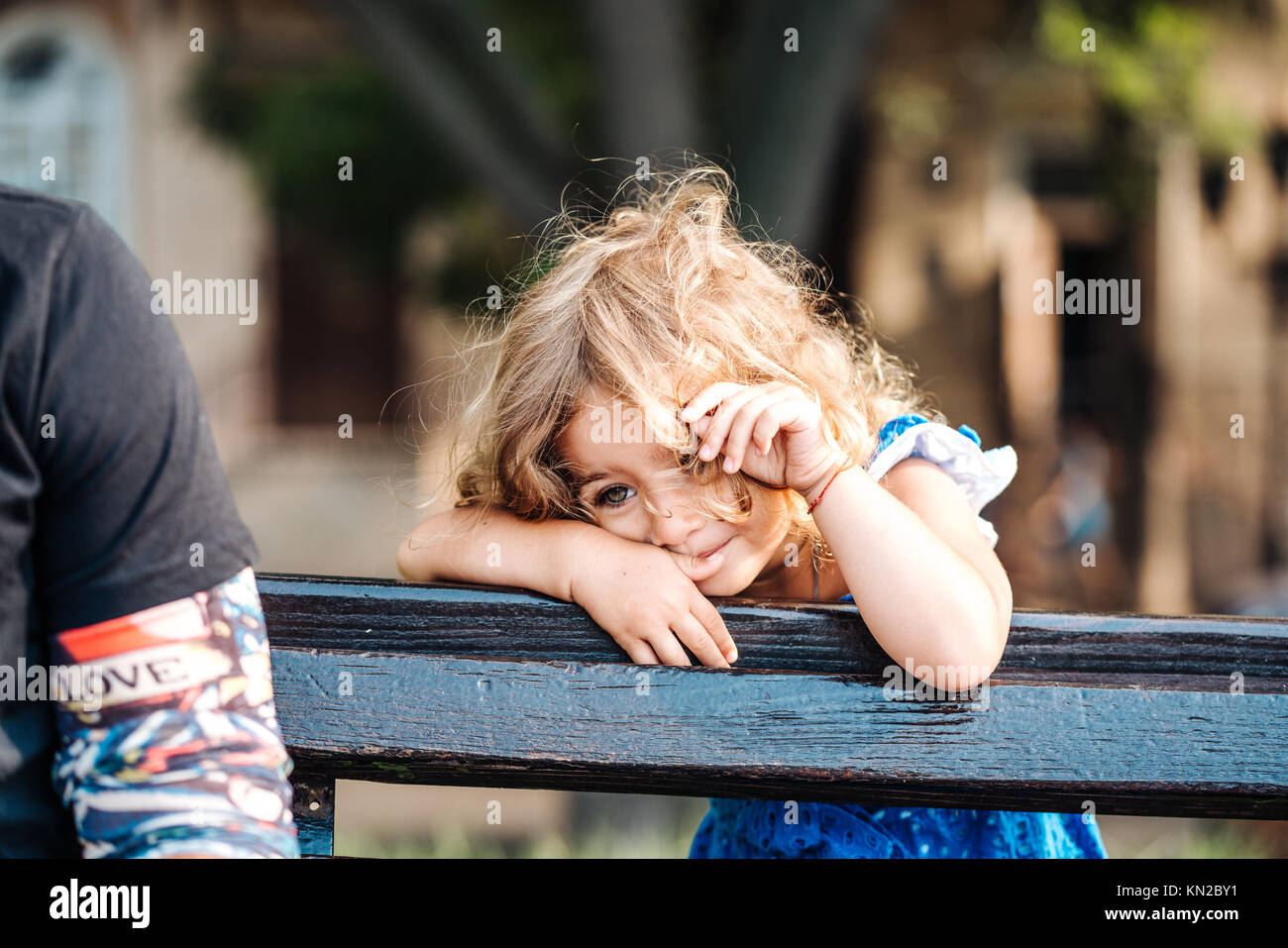 toddler girl standing behind a bench Stock Photo - Alamy
