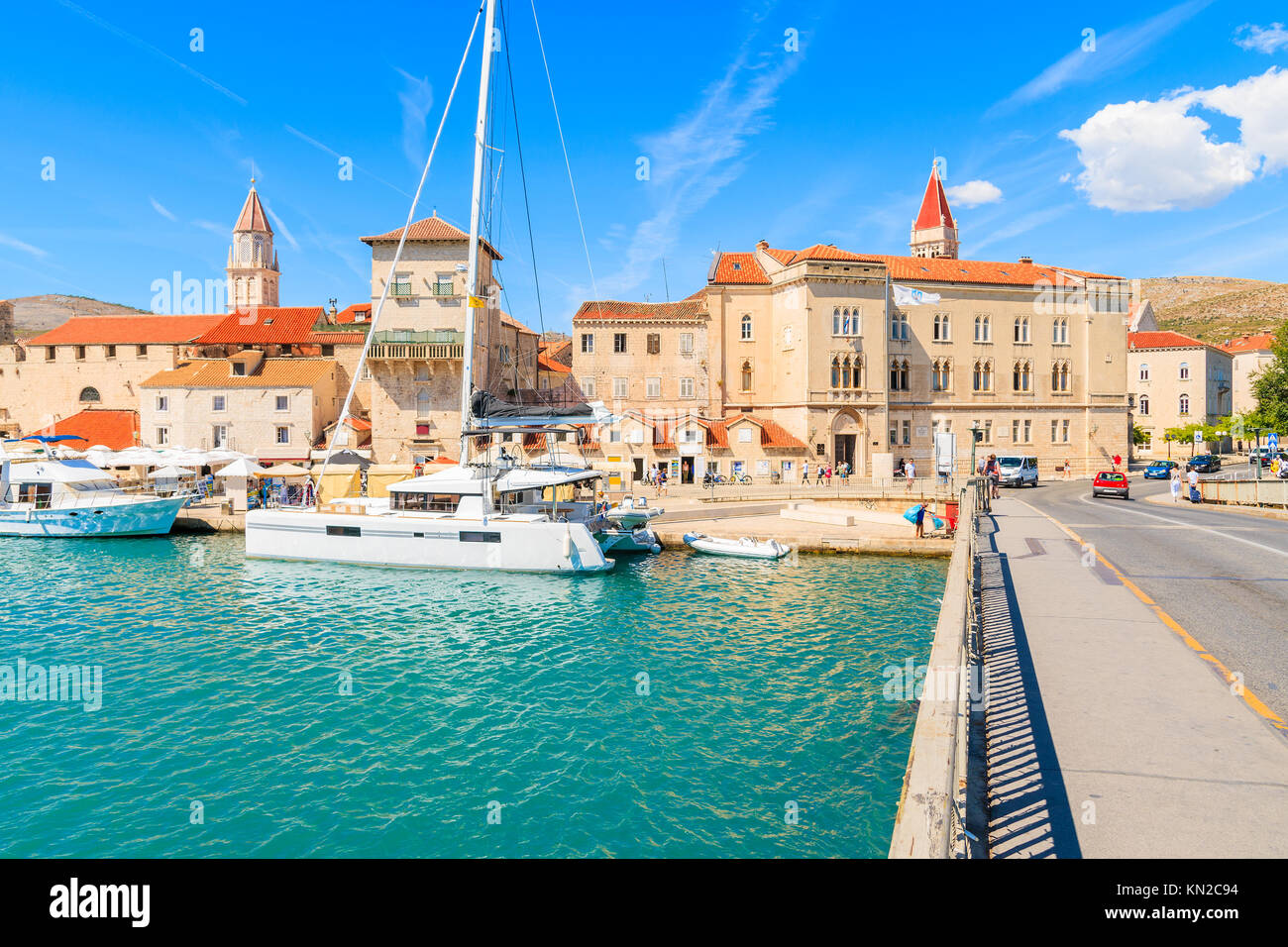 View of historic buildings and catamaran boat in Trogir town from bridge over canal, Dalmatia, Croatia Stock Photo